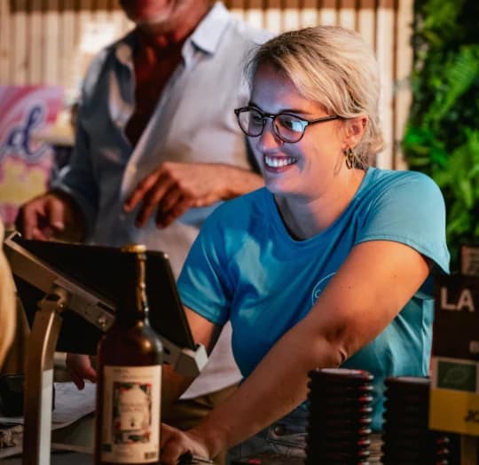 Serveuse souriante derrière le comptoir d'un bar de camping
