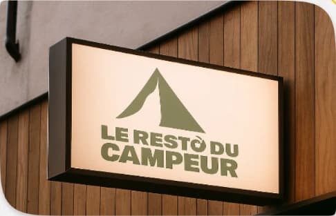 Enseigne lumineuse Le Resto du Campeur sur une façade en bois