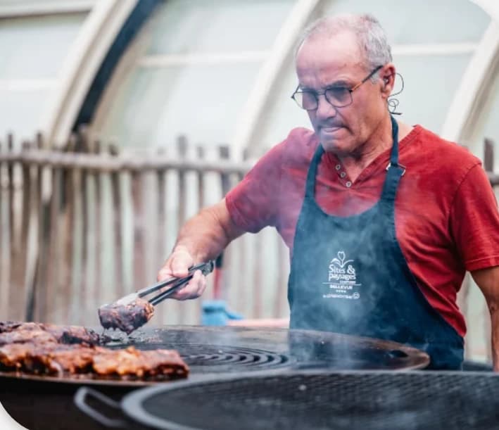 Un gérant FnB fait griller des viandes au brasero