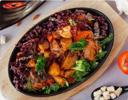 Plat à partager servi en cocotte sur une planche