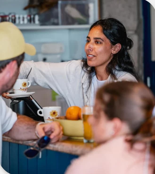 Une gérante discute avec des clients au comptoir